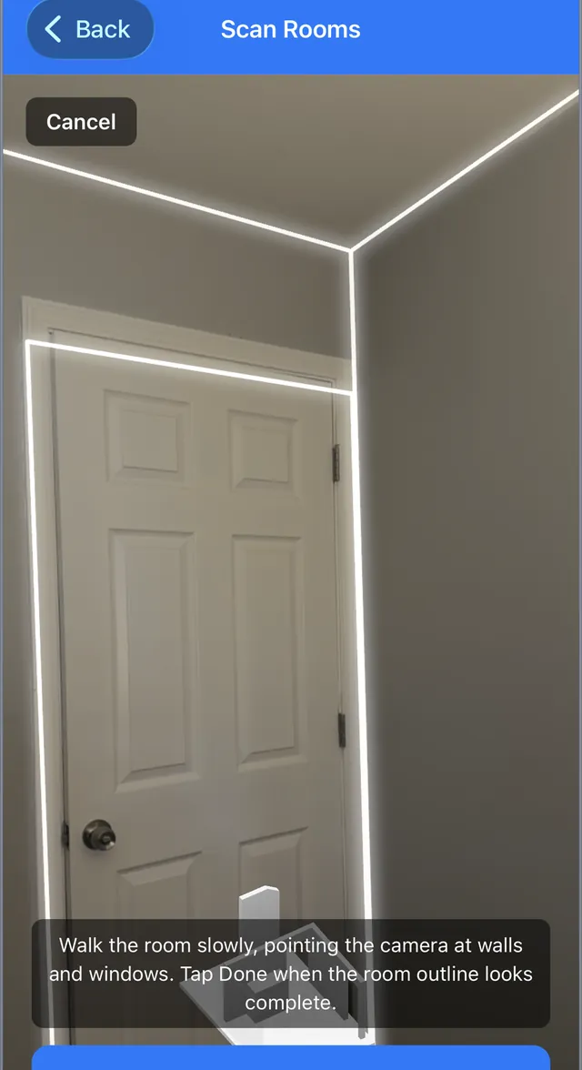 LiDAR room scan in progress, with the app tracing glowing outlines along the walls, ceiling, and door frame of a room